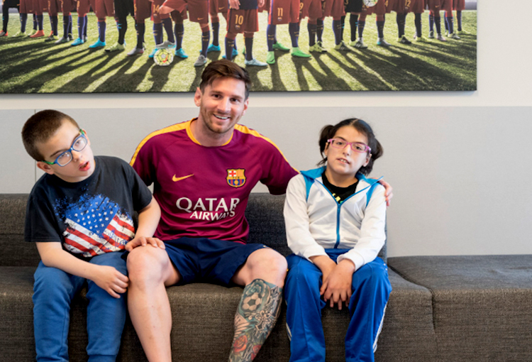 Lionel Andrés Messi and two kids of his foundation
